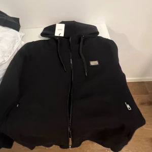 Svarta mjukisbyxor från Dolce & Gabbana - Svarta mjukisbyxor från Dolce & Gabbana med metallogo framtill. Byxorna har dragsko i midjan och dragkedjor på fickorna. Tillverkade i mjukt bomullsmaterial för en chill och avslappnad look Storlek L men passar M. Pris går och negotiera 