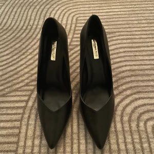 Svarta pumps med spetsig tå - Snygga svarta pumps från Primark med spetsig tå och hög klack. Köpt på vinted men inte använd från mitt håll, några få skavanker på underdelen av skon men annars jätte fina!