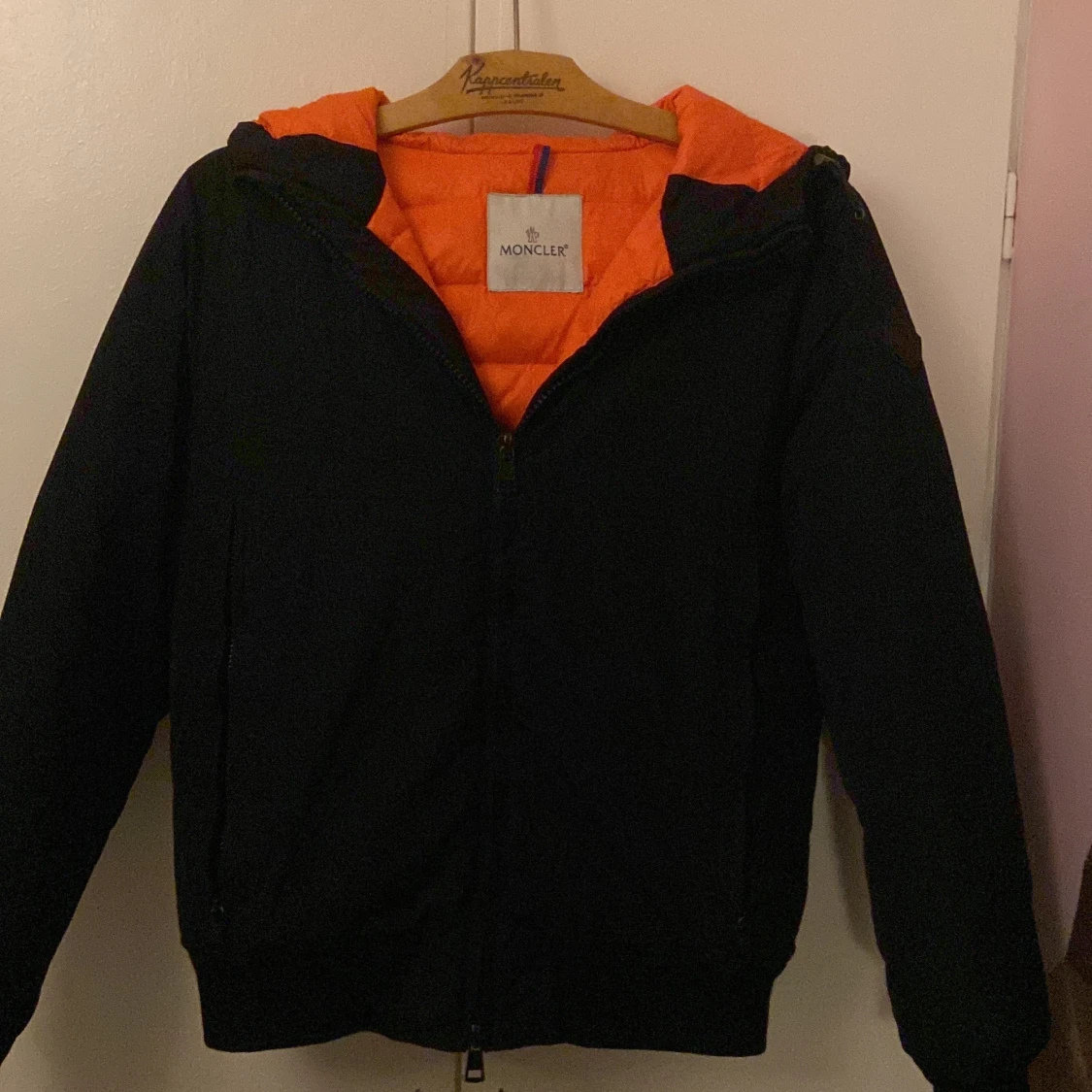 Svart Moncler pufferjacka med orange foder