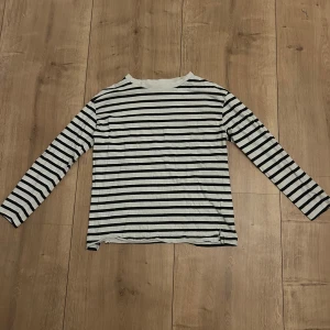 Randig långärmad tröja - Säljer en vit och svart långärmad tröja från lager 157, inga defekter och använd ett fåtal ggr❣️