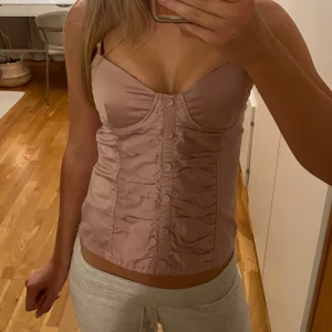 Rosa korsett-topp  - rosa/beige korsett topp med snygga detaljer och knappar💕💕 står storlek M men passar även S och Xs skulle jag säga 