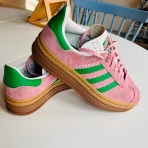 Adidas Gazelle bold stl 38 2/3-  rosa/gröna sneakers - Säljer ett par Adidas Gazelle bold sneakers i rosa mocka med gröna detaljer och klassiska tre ränder på sidan. Stl 38. 2/3. Bra skick. 