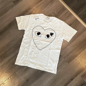 Commes Des Garçons T-shirt CDG Play - Säljer denna helt nya, riktigt fina CDG T-shirten i en av de snyggaste modellerna. På tröjan står det M men den passar S. Skriv gärna vid intresse och för mer information! 