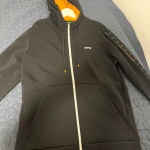 Svart hoodie från BOSS med dragkedja - Helt ny Hugo boss hoodie med storlek L. Den är för stor för mig jag är 185cm och väger 79kg