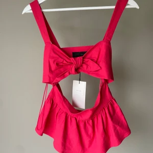 Röd öppen topp från Zara - Superfin rosa linnetopp från Zara med breda axelband, rosett framtill och cut-out under bysten. Toppen har volang nertill och är tillverkad i en luftig linneblandning. Aldrig använd med lappen kvar💞