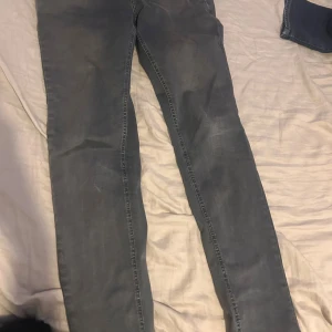 Replay jeans i grå skinny fit - Snygga grå jeans från Replay i modellen skinny fit. Byxorna har klassisk femficksdesign, knappstängning och smal passform hela vägen ner. Materialet är mjukt och stretchigt jeans, perfekt för dig som gillar en tajt look.