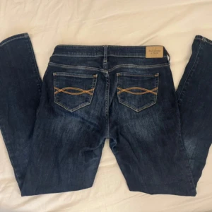 Mörkblå jeans - Snygga mörkblå jeans från Abercrombie & Fitch, de är lågmidjade och bootcut. Storlek W27 L31 passar mig som är 165 och brukar ha xs/s i jeans! Köp direkt för 149kr via köp nu💞💞😍