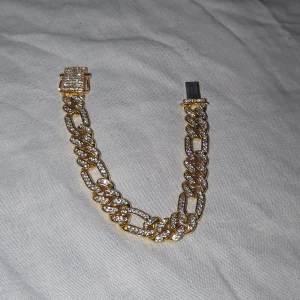 Guldpläterat armband med moissanite stenar  - Armbandet är pläterad i guld och inte säker på vad det är för metall under. Använt endast 5-6 gånger då det är lite för stort för mig. Köpt online för 650kr. Armbandet har ett magnet spänne och två hakar så det sitter bra.