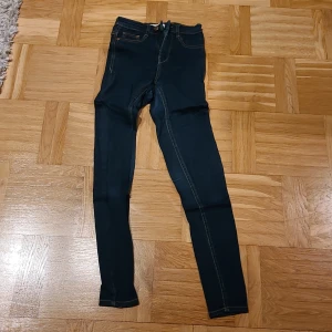 Mörkblå Molly jeans XS från g perfect jeans - Snygga mörkblå Molly jeans från g perfect jeans i storlek XS. Modellen är skinny med klassisk femficksdesign, gul kontrastsöm och dragkedja fram. Jeansen har hög midja och är tillverkade i stretchigt jeansmaterial för en tajt passform.