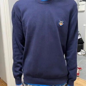 Mörkblå stickad Kenzo tröja - Säljer denna kenzo tröjan. Riktig snygg och passar nästan till alla olika stilar. Storlek är M. Vid frågor är det bara att höra av sig. Kan gå ner i pris vid snabb affär 