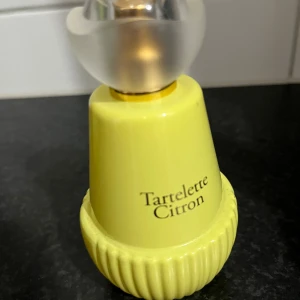 Tartelett Citron parfymflaska - Snygg parfym i lekfull gul flaska med cool design.  Luktar krämig citron, vanilj och har en perfekt fruktig gourmand lukt. Perfekt för dig som vill sticka ut och addera en färgklick till din samling. Namnet ger vibbar av fräsch energi.