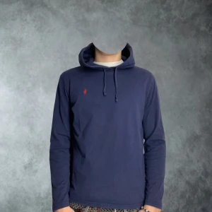 Polo Raplh Lauren hoodie/tröja marinblå i size medium - Snygg marinblå hoodie från Polo Ralph Lauren med klassisk röd logga broderad på bröstet. Tröjan har huva med snörning och långa ärmar. Tillverkad i mjuk bomull som gör den stilig och komfortabel. Perfekt för chill dagar och enkel att matcha med jeans eller liknande. Tröjan är i mycket bra skick förutom liten skada vid märket samt en väldigt liten sömma som frånvarande. Ingenting som syns med ögat                             ( kolla gärna bild) tveka ej vid prisförslag😁