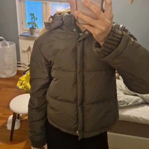 Mörkgrön pufferjacka med huva - Säljer min mörkgröna pufferjacka med stor huva! Står XL men passar mig som har s/m