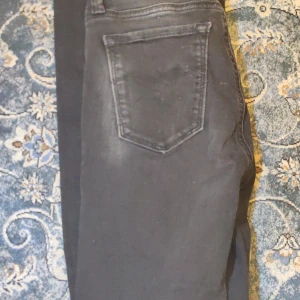 Svarta  jeans från Replay - Snygga svarta jeans från Replay med klassisk bakficka och diskret logga i metall. Modellen är skinny fit med smala ben och normal midja. Jeansen är tillverkade i stretchigt bomullsmaterial för en bekväm passform och har en stilren look som passar till det mesta.