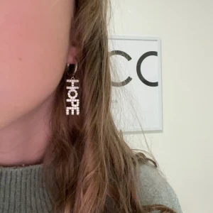 HOPE örhänge - Ett jättefint silver örhänge med texten Hope den är från IOaKU. Säljer då jag har tröttnat lite på det 