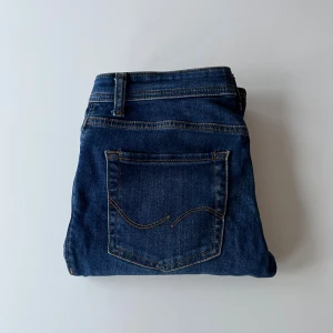 Jack & Jones Slim fit jeans blå - Snygga blå jeans från Jack & Jones, modell Slim Glenn. Storlek 29W 30L. Jeansen har en slim passform, klassisk femficksdesign och är tillverkade i stretchig denim för extra komfort. Jeansen är endast använda ett fåtal gånger. Perfekta för dig som gillar en smal siluett och stilren look. Jag är cirka 170 och kan fortfarande ha dem. De är storlek 158 men passar större.