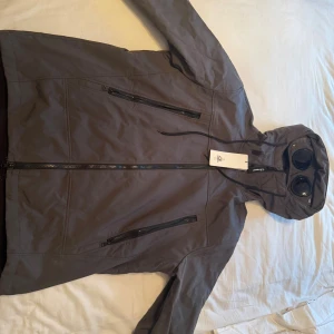 C.P Company Shell-R Jacket - Tjena! Säljer nu min gråa cp company jacka som är helt sprillans ny. Fick den i födelsedagspresent för 1 år sen och har inte använt den då den inte passar min stil alls. Skit fet jacka som passar till mycket. Om ni har några frågor eller så så är det bara att slänga iväg ett meddelande! OBS, kan gå ned i pris vid snabb affär