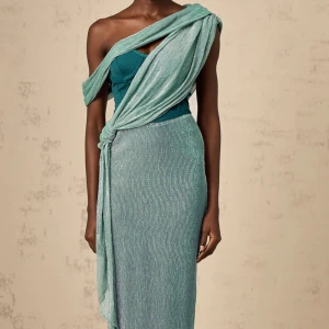 Miss rosier turkos glittrig långklänning oneshoulder  - Säljer en turkos glittrig långklänning med oneshoulder och draperad omlott-detalj över axeln från miss rosier. Klänningen har en smal passform och slits bak. Materialet är glittrigt och skimrande, perfekt för att sticka ut. Snygg knut i midjan och elegant fall. Helt ny oanvänd.