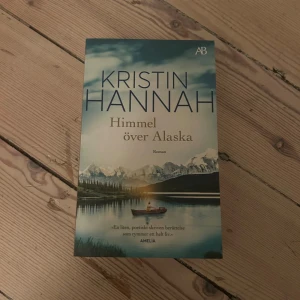 Himmel över Alaska - En poetiskt skriven roman som tar dig till Alaskas vackra och vilda natur. Perfekt för dig som gillar gripande berättelser och vill drömma dig bort till nya platser. Omslaget visar majestätiska berg och en stilla sjö – en bok för dig som söker äventyr och känslor.
