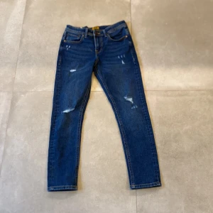 Jack and Jones jeans  - Säljer ett par Jack and Jones jeans med slitningar i modellen Slim GlennAldrig använt helt nya.  Storleken är 14y 