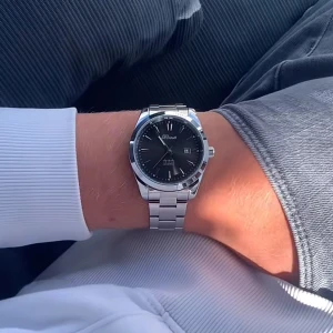 Svart och silver klocka från Doventi  - Stilren klocka från Doventi med svart urtavla och silverfärgat armband i metall. Rund boett, tydliga index och datumvisning. Klassisk design som passar till många outfits och ger en clean vibe. Perfekt för dig som gillar enkla och snygga accessoarer.