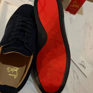 Mörkblå Christian Louboutin - Snygga mörkblå sneakers från Christian Louboutin med klassisk röd sula, Helt nya och oanvända.                                                  priset kan diskuteras.