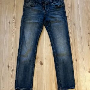 Blå slim jeans Jack & Jones 32/30 - Säljer ett par blå slim fit jeans från Jack & Jones, modell Glenn med superstretch för extra komfort. Jeansen har klassisk femficksdesign, knappgylf och snygga slitningar framtill. Perfekt passform och stilren look.