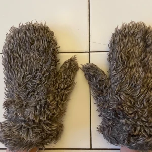 Bruna fluffiga pälsvantar - Säljer ett par riktigt fluffiga och varma bruna vantar med pälsimitation. Vantarna har en grov, lockig yta och tumme, vilket ger dem en unik och mysig look. Perfekta för dig som vill sticka ut och hålla händerna varma under kalla dagar.