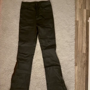 Svarta bootcut byxor i syntet - Snygga svarta byxor med bootcut och klassisk femficksdesign. Materialet har en lätt glansig finish/skinn. Passar dig som gillar stilrena och trendiga byxor med lite extra edge. Perfekt till sneakers eller boots. Vid fler frågor och bilder, så är det bara och skriva🤍