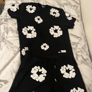 Denim - Svart t-shirt med coola vita blommönster över hela plagget. 