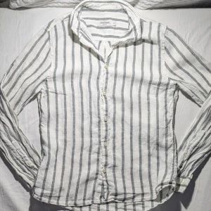 Dressman linneskjorta - En linneskjorta från Dressman i storlek XS. Skjortan är i ett mycket bra skick och bar använda ett fåtal gånger, skjortan är vit och grön randig 