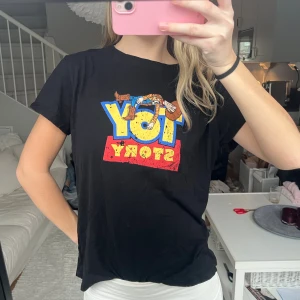 Svart Toy Story t-shirt med tryck - Svart t-shirt från Disney med färgglatt Toy Story-tryck på bröstet och motiv av Woody 🫶🏼Går att använda till vardags eller som en mysig sovtröja! Använd fåtal gånger, storlek L men passar mig som är storlek S 🌟
