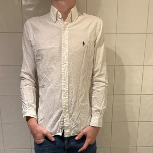 Vit skjorta från Ralph Lauren - Klassisk vit skjorta från Ralph Lauren, i fint skick förutom att den är lite skrynklig. Jag på bilden är 184cm lång och väger 70kg. Hör av er vid frågor eller funderingar!✌️🤩