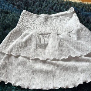 Vit kjol - Vit kjol från Gina Young, väldigt väldigt lite använd. Med fina volanger. Storlek 146-152 i barn storlek 