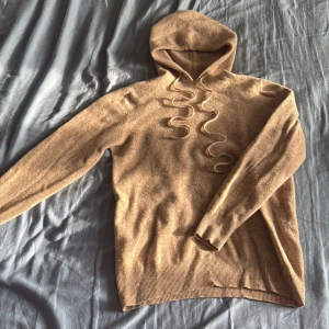 Beige stickad hoodie med snörning - Mysig beige stickad hoodie med långa ärmar och snygga snören. Körde den i tvätten o vips så vart den mindre. När jag köpte den fanns de inga tag’s varifrån den va. Passar xs/s