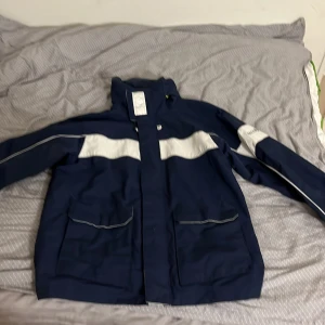 Blå vindjacka Race Marine XS - Snygg marinblå vindjacka från Race Marine i storlek XS. Men passar även S Jackan har vita detaljer på bröstet och ärmarna, hög krage och stora fickor framtill. Materialet är slitstark polyester och jackan har en sportig look med coola kontrastpaneler. Tveka inte på att fråga eller ge bud 
