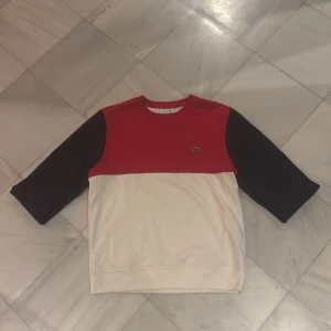 Röd och vit Lacoste sweatshirt M - Marinblå/röd/vit Lacoste tröja i mycket bra skick. Sparsamt använd. Köptes för 1200 