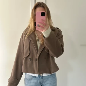 Jacka - Brun begige trenchcoat i ett tjockare material. Tillverkad i Italien så snygg nu till hösten. 