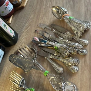 Bestickset V.P.C.P. silverpläterad - Elegant vintage bestickset i silverpläterad metall från V.P.C.P. med vackra, detaljerade ornament. Setet innehåller knivar, gafflar och skedar i gott skick, med mindre tecken på normalt bruksslitage. Perfekt för festliga tillfällen eller samlare av klassiska bestick.