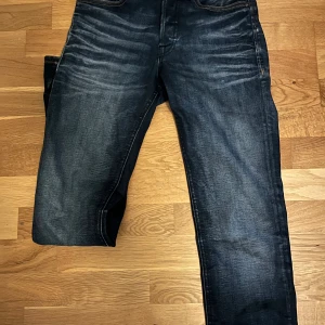 Mörkblå jeans från Jack&Jones - Snygga mörklblå jeans från Jack&Jones i storlek 27/32. Jeansen har en cool wash och är slim straight. 