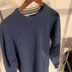 Citta di Milano blå tröja - storlek M - Snygg och bekväm tröja från märket Citta di Milano i en fin blå färg. Perfekt för både vardagsbruk och till lite mer uppklädda tillfällen. Tröjan är i storlek M och har en klassisk rund halsringning med ribbad kant. Materialet känns mjukt och skönt mot huden.