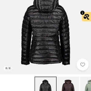 Svart pufferjacka med huva - Snygg svart pufferjacka med huva och dragkedja framtill. Jackan har ett quiltat mönster och är tillverkad i glansigt syntetmaterial. Passformen är normal och jackan har långa ärmar samt praktiska fickor på sidorna. Perfekt för kalla dagar. 