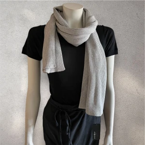 Ljusgrå ribbstickad halsduk Sail Racing - En ny ljusgrå halsduk från Sail Racing i ribbstickad design. Halsduken är lång och mjuk, perfekt att vira flera varv runt halsen. Enkel och clean look som passar till många outfits.#sailracing #halsduk