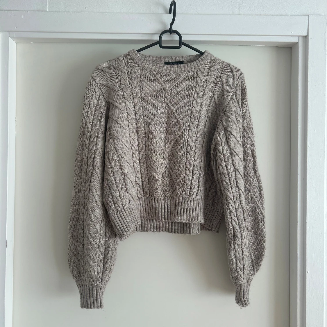 Beige stickad tröja med flätmönster