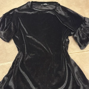 En svart glittrig tröja  - En jätte fin svart glittrig tröja perfekt till lite finare tillfällen. Köpt utomlands väl omhändertagen och är underbart fin.
