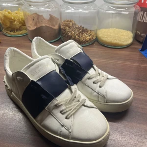 Valentino Open sneakers vit/marinblå - Valentino Garavani Open i storlek 44, lite sliten i sulan ( sista bilden ) men inget som är så farligt. Bra helhets intryck. Ev kopior där av priset