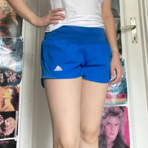 Blå trängashort adidas  - Snygga träning shorts med inbygg ”Trosa”. Jag kan mötas upp i Uddevalla centrum, annars fraktar jag gärna. Köparen står för frakten. (Står ej för postens slarv) katt finns i hemmet. 