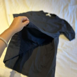 Mörkblå basic t-shirt i bomull - Enkel och stilren mörkblå t-shirt med rund hals och korta ärmar. Tillverkad i mjuk bomull, perfekt för en clean och avslappnad look. Passformen är normal och materialet känns skönt mot huden.