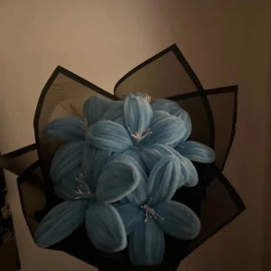 Blåa evighets liljor  - LÄS!!! En unik bukett med stora, ljusblå liljor. Blommorna är arrangerade i ett svart, stilrent papper. Finns även i andra färger allt information finn på insta - floraforever1. Perfekt som dekoration eller present till någon som gillar annorlunda detaljer