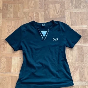 Svart D&G t-shirt med v-ringning - Svart t-shirt från D&G och är storlek L men passar mig som brukar ha s